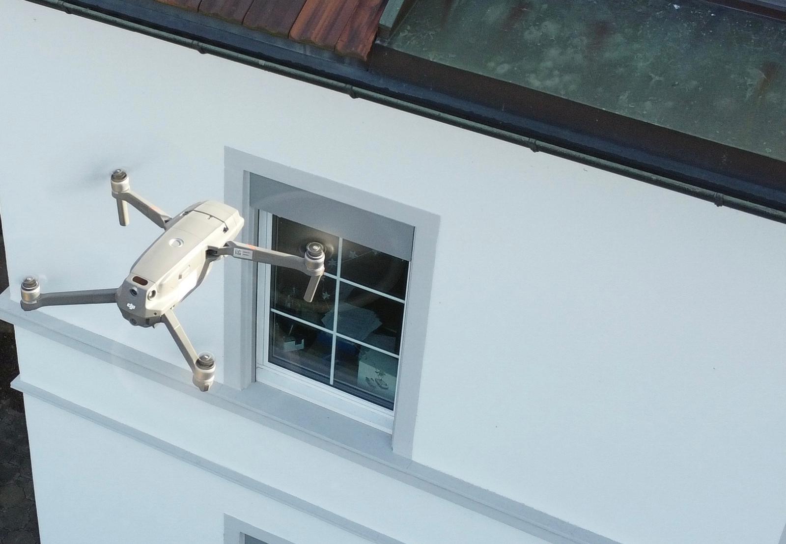 Drohne vor Hausfassade und Fenster